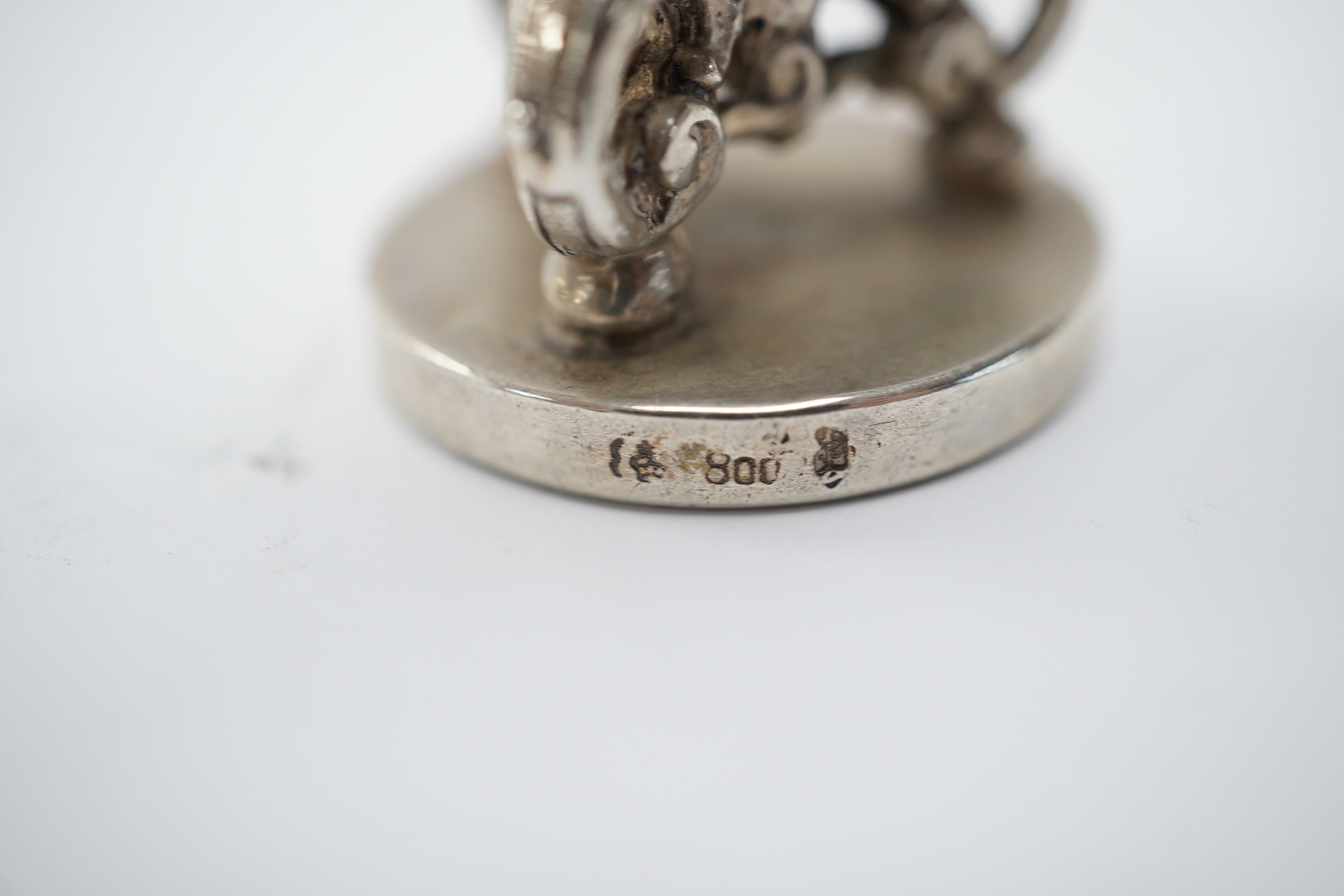 An early 20th century German 800 standard figural desk seal, modelled as a musician, 68mm. Condition - fair to good